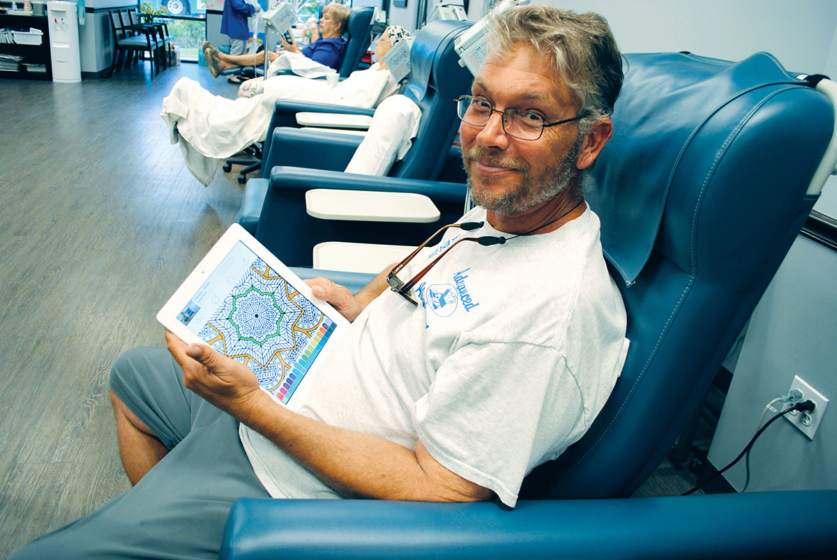 John Steak occupies his time while getting a transfusion.