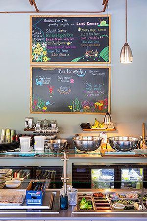 A chalkboard above the salad preparation area