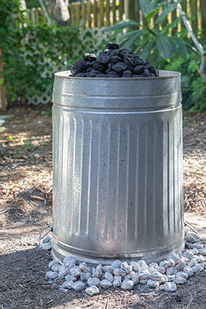 The trash can is placed over the turkey, surrounded and topped by coals.