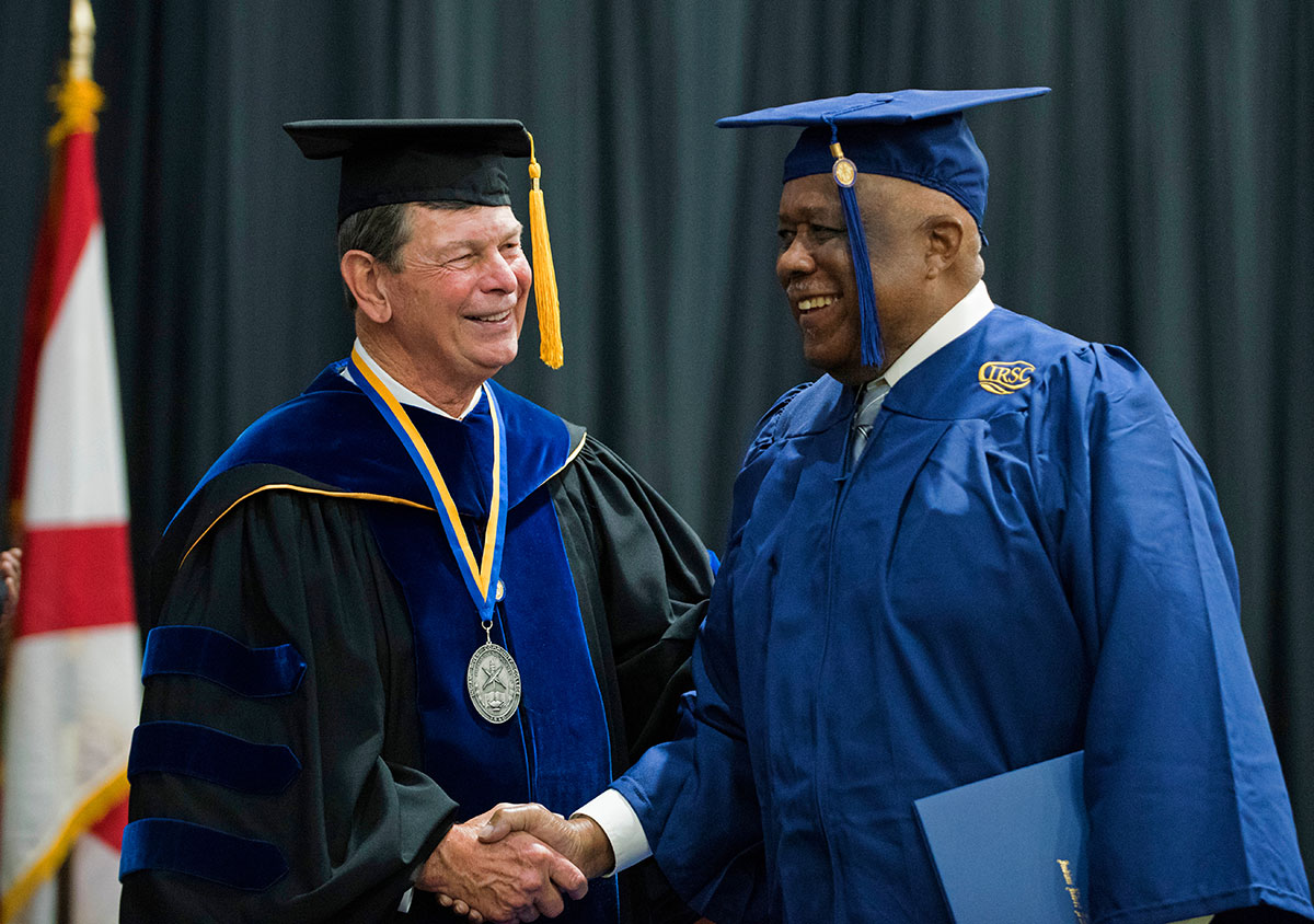 Dr. Massey congratulates a new bachelor’s degree graduate at Commencement
