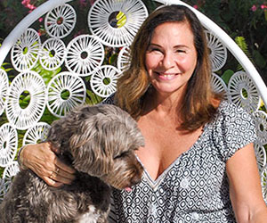 Pamela Caragol of Vero Beach, executive producer for National Geographic, relaxes on her pool deck with her faithful companion Cooper.