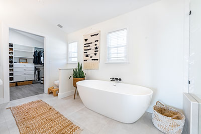 The pristine white master bath suite is offset by subtle shades of white oak and teak.