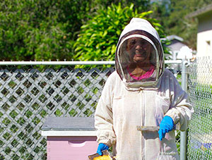 Dana Fisher dons her beekeeper suit to harvest honey in her backyard apiary.