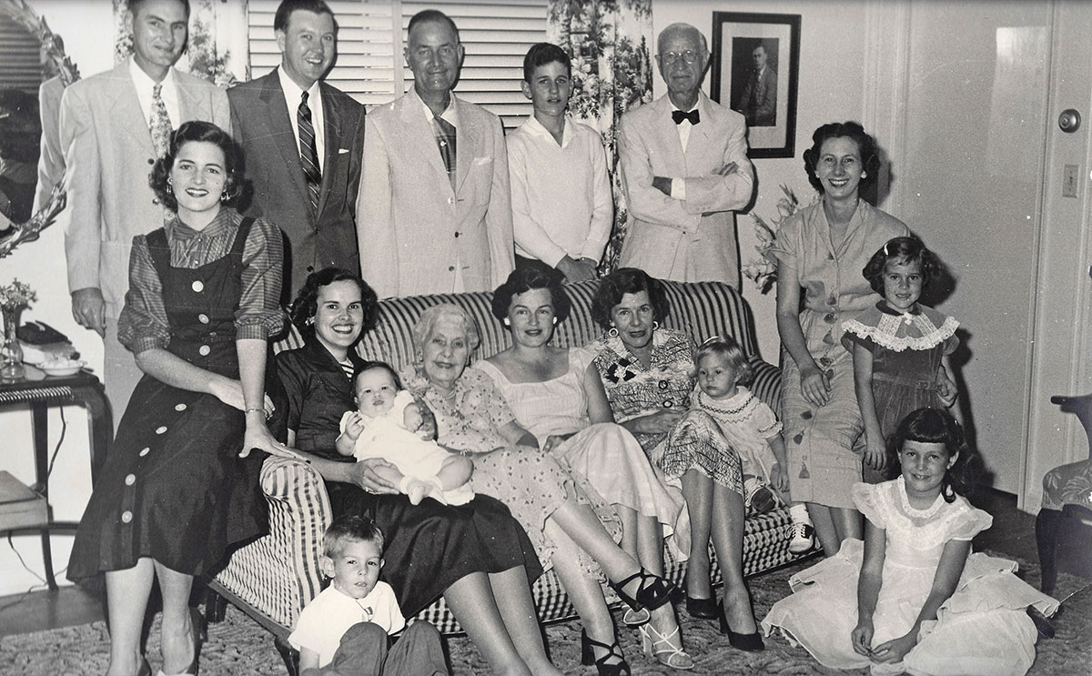 Four generations of Koblegards gathered for this family portrait on Thanksgiving in 1955 at R.N. ‘Pop’ and Rose May’s home on Colonial Road, later the home of Realtor Hoyt C. Murphy. The men in the back row are Ruhl W. ‘Sonny’ Koblegard Jr., Sinclair Harcus, Rupert Koblegard Jr., Rupert ‘Koby’ Koblegard III, and Pop Koblegard. From left in the middle row are Mary Ann Koblegard [Bryan], Frances ‘Sissy’ Koblegard Harcus and son Sinclair Harcus Jr., Rose May Koblegard, Mary Koblegard, Marjory Koblegard, Christine Koblegard, Hazel Koblegard, and Laura Lee Koblegard. The two children sitting on the floor are Ruhl W. ‘Chip’ Koblegard III and Wendell May [Wendy] Koblegard.