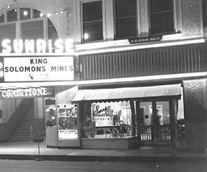 The Whizateria was a storefront fixture at the Sunrise Theatre from 1923 to 1953, operating variously as a confectionary and smoke shop and restaurant. Here it appears about 1950 after the theater’s new lighted marquee was installed and air-conditioning was introduced.