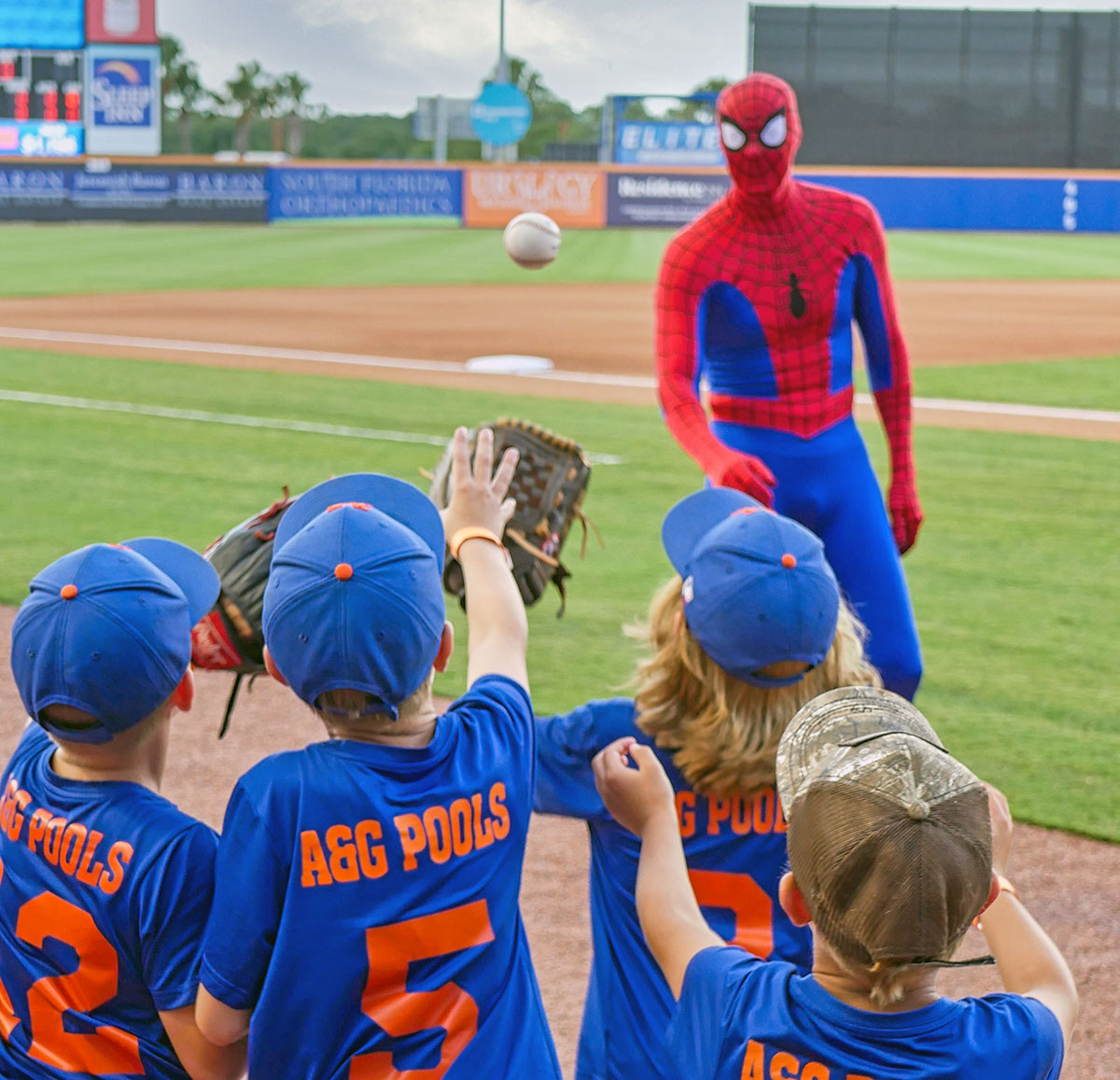 The A&G Pools Mets of the Port St. Lucie National Little League have a ball, playing catch with Marvel superhero Spider-Man at Clover Park.