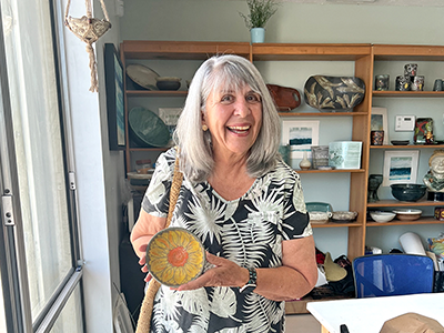 Linda Scalfo holds a sunflower bowl Sullivan made for her.