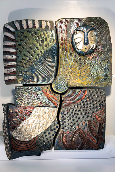 Sullivan created this abstract bas-relief piece she titled Alaskan Confluence
using a unique glazing method called Raku. This method results in an iridescent,
metallic-like finish to the piece of art.