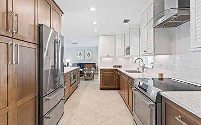 Sleek appliances and top-notch wood cabinetry grace the kitchen, complemented by a stark white backsplash and a row of white cabinets.