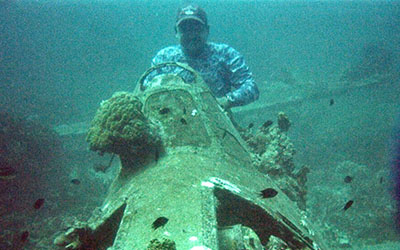 Beach jumped into the cockpit of a sunken Hellcat while diving, taking off his diving mask briefly for the photo.