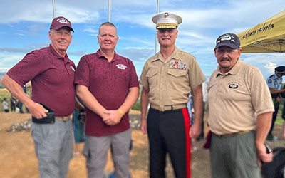 Visitors pose with Lt. Gen. Steven R. Rudder, commander of the Marines in the Pacific. Military officials and visitors honored past warriors of Guadalcanal with Dana Beach on the right.