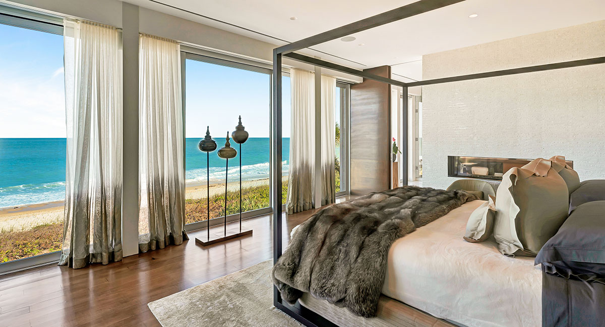 The luxurious second-floor primary suite offers unobstructed ocean views, a double-sided fireplace, and a 20-foot walk-in closet.