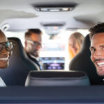 Group Of Cheerful Multi Racial Friends Sitting In Car Enjoying Road Trip Travel
