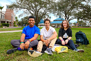three Highschool students sitting on the lawn