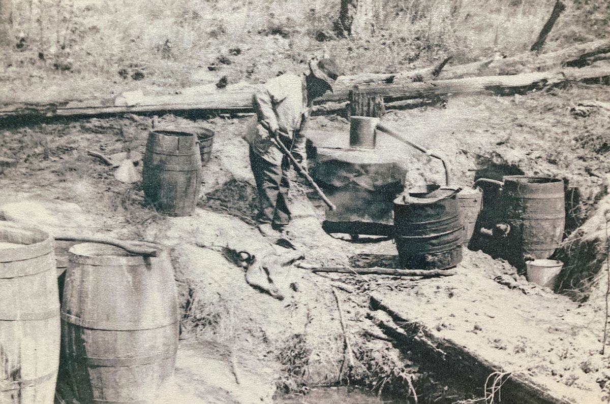 A worker for the Ashley family tends one of their stills.