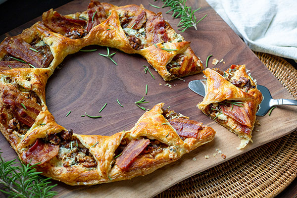 A savory wreath of golden, flaky pastry filled with caramelized onions, gorgonzola, walnuts and bacon is a tasty addition to a holiday party table.