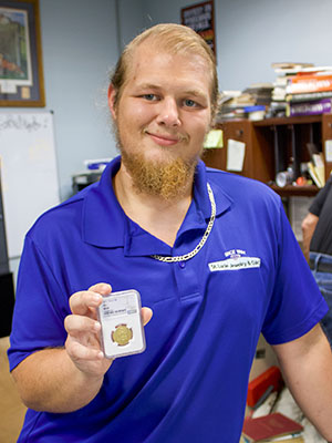 Numismatist Hunter Springsteen holds a valuable gold coin to show just one among the countless types of currency he deals with on a regular basis. WHITNEY JOSEPH