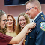 Emma Whitten pins her father’s new shield with wife Denise and daughter Brooke looking on proudly.