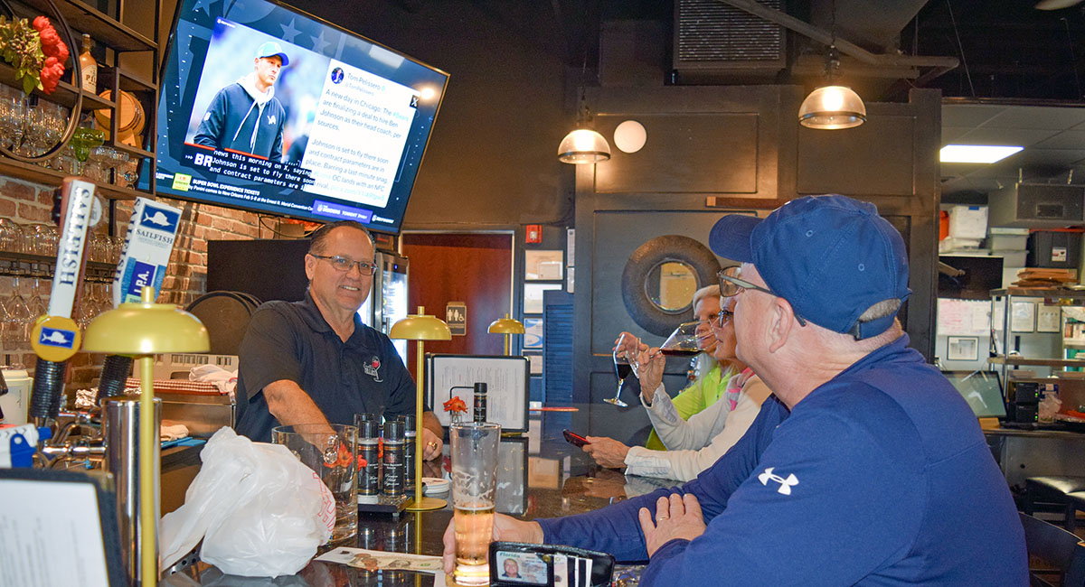 Ken Gibson, owner of Downtown Cellars along with Trina Angelone, chats with customers visiting the new wine bar on Melody Lane. Online comments are complimentary of the food served at the bar.